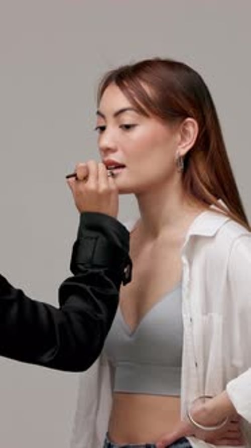 Girl, model and artist with makeup in studio for lipstick application, cosmetics