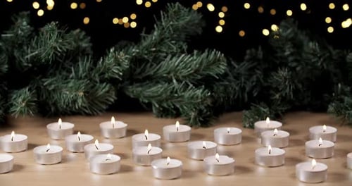 dekoratives Weihnachtsdekor mit vielen Teelichtern auf einem Tisch und flackerndem Licht im Dunkeln blau