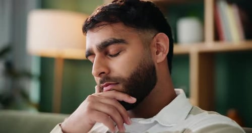 Man, thinking and sad in lounge with anxiety from bad memory, conflict or news in home