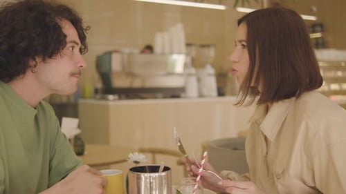 A Young Couple Eats Drinks Coffee and Talks in a Very Beautiful Cafe A Guy and a Girl are in a Very