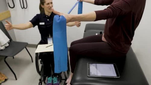 Woman exercises with physical therapist in hospital setting