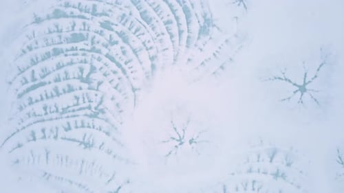 Drone Flying Over Natural Snow And Ice Patterns In Frozen Lake