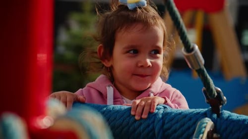 Joyful Child Playing on Outdoor Playground Equipment Smiling and Enjoying Time with Friends While