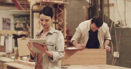 Woman, tablet and internet connection for carpentry in a workshop or small business