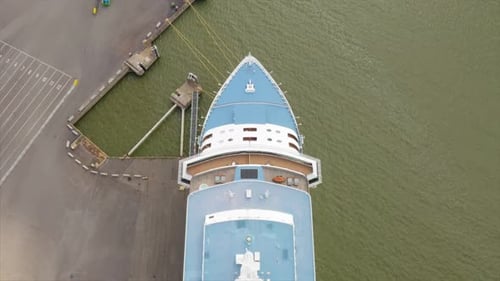 Luxury cruise ship alongside in port. Mooring lines secured. Radars rotating. Aerial top down view f