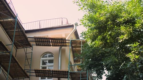 Scaffolds with Frame and Wooden Grounds Near Old Building