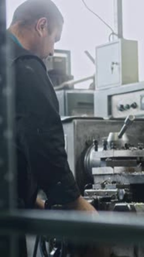 Experienced machinist using lathe in industrial setting
