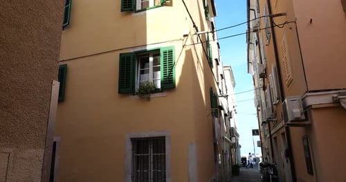 Traditional houses in old Mediterranean town, windows with shutters, narrow streets and blue sky