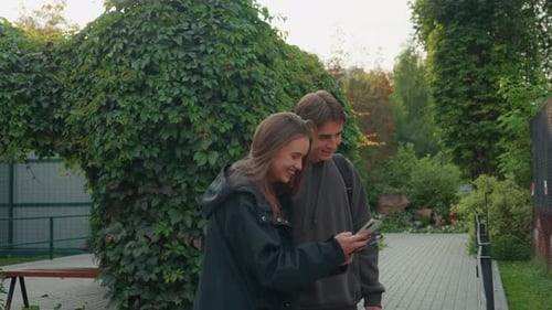 Friends Reviewing Trip Plans Together Young Friends Enjoying Time in Garden Setting Relaxed Couple
