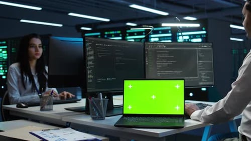 Zoom in on Green Screen Laptop Used By Data Center Worker Troubleshooting Issues