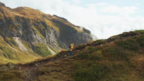 Hiker Walks on High Mountain Range Top Exploring Nature
