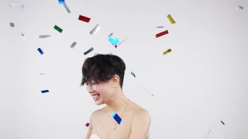 Dance, woman and confetti in studio for party, celebration and success against a white wall mockup