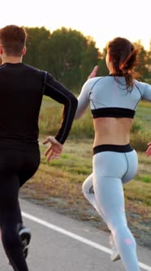 Couple Running Together on Rural Road at Sunrise