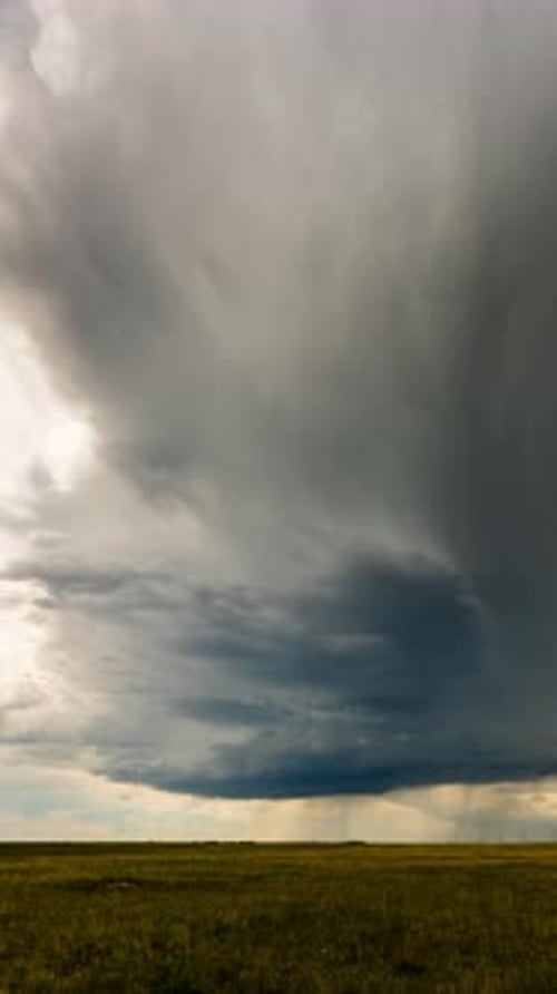 Ominous Storm Clouds Over Grassy Plain on Overcast Day