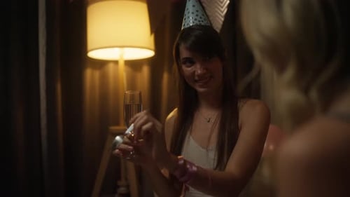 Over the Shoulder a Happy Brunette Girl in a Blue Nightcap Holds a Glass of Champagne in Her Hands