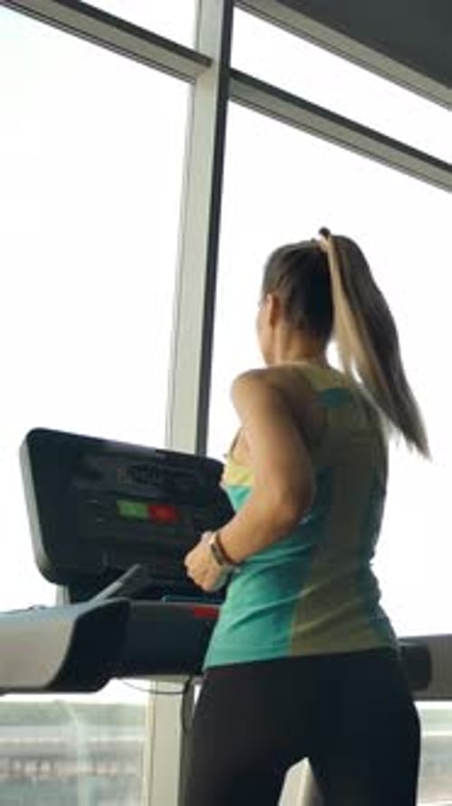 Vertical of Athletes in the Gym is Engaged on Treadmills