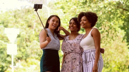Three smiling friends taking a selfie together