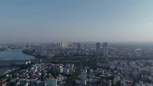 Panning reveal of Saigon River skyline on clear sunny morning with blue sky in Vietnam