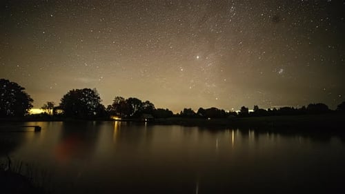 Timelapse d'un lac du ciel nocturne reflétant des étoiles filantes dans l'espace, silhouette d'observation des étoiles