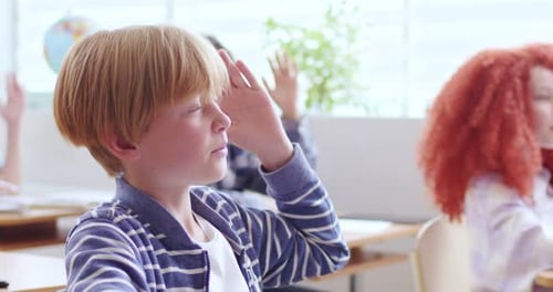 Cute Boy in Casual Wear Raising Hand and Answering Teacher's Question During Lesson at School Smart