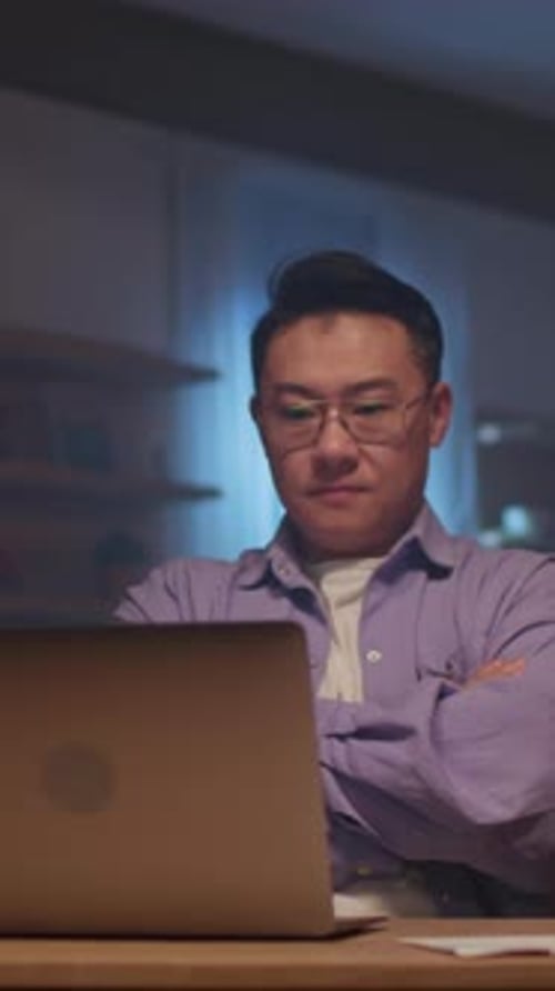 Man Working at Desk with Laptop and Documents
