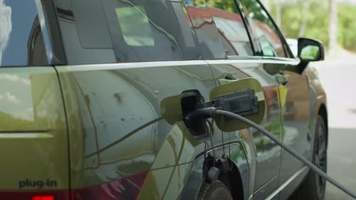 Close Up of Man Closing Vehicle Inlet of EV Eco Friendly SUV Car After Charging