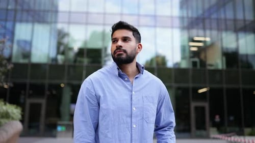 Confident Young Man Giving Thumbs Up Near Office
