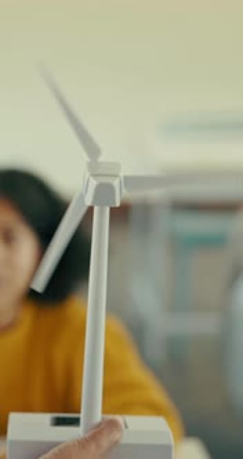 Hand, wind turbine and teaching with students in classroom for education