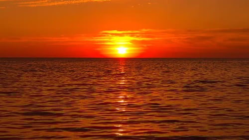 Sunset Ocean Water Golden Orange Sun Setting Over Tranquil Sea with Vibrant Light Reflection