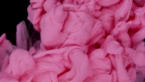 Swirling Light Pink Ink Against Black Background