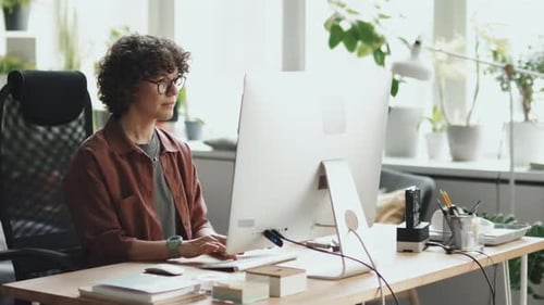 Woman Working at Computer in Bright Office