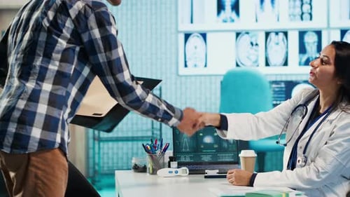 Doctor Meeting Patient and Reviewing Documents in Office