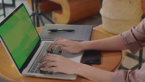Woman Sitting Alone Working Typing Keyboard on Laptop Computer Green Screen at Cafe Coffee Shop