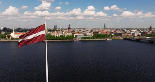 Beautiful Aerial View Above Riga, Latvia as Latvian Flag Waves in Wind