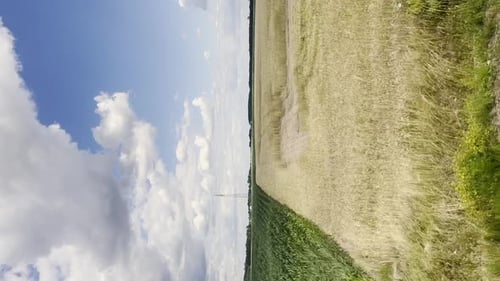 Vertikaler Blick auf gelbe Felder und bewölkten Himmel vom Seitenfenster schneller Hochgeschwindigkeitszugfahrten auf der