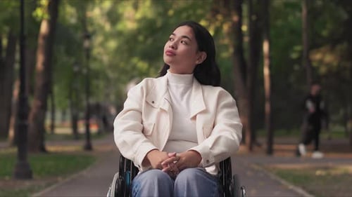 Young Woman in Wheelchair Smiling in Park