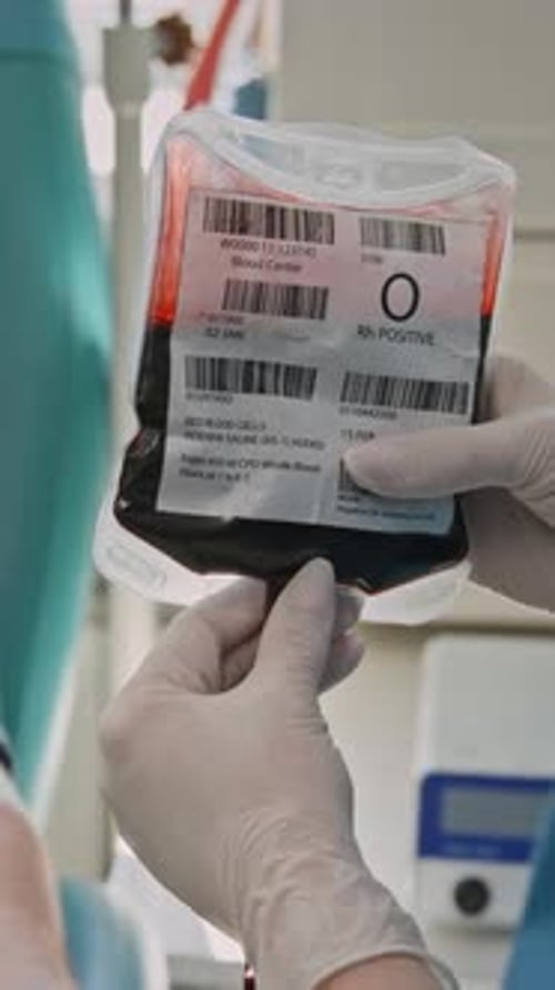 Close-up of Unrecognizable Nurse Examining Blood Bag After Donation in clinic