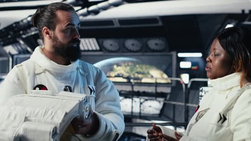 Der Astronaut setzt den Helm auf, bevor er die Raumstation verlässt, und stößt seinen Kollegen mit der Faust