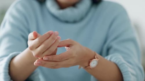 Frau knackt Knöchel an ihren Händen, Angst und nervöse Geste