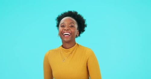 Woman Smiling and Laughing in Front of Blue Backdrop
