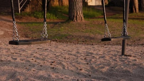 Empty swings swinging alone in the wind.