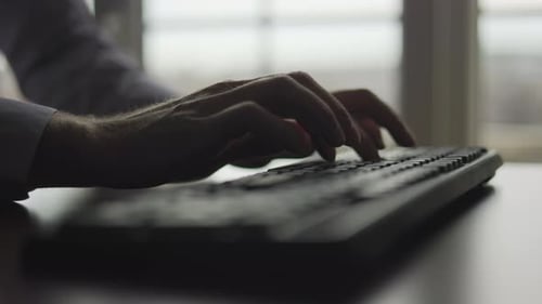 Escribe en el teclado las manos de un empleado de oficina sobre el teclado con los dedos, presiona las teclas y escribe