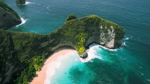 Unberührter Sandstrand Kelingking auf der Insel Nusa Penida, Bali, türkisfarbenes Meerwasser vor grünem Kalkstein