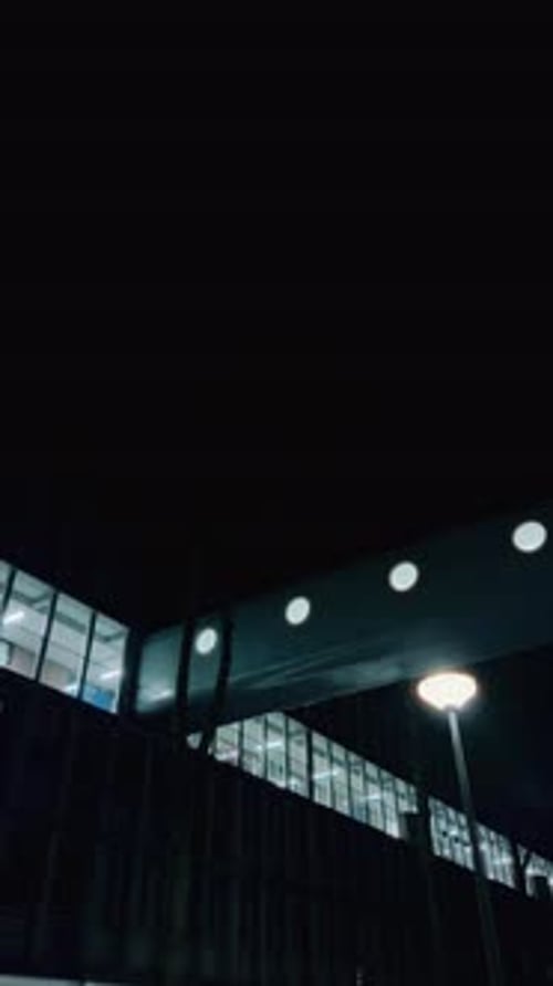 Modern pedestrian bridge at night with bright windows Amsterdam Buikslotermeerplein