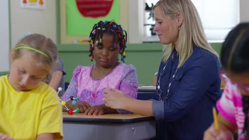 Teacher and Student Work on Science Model Together in School Classroom African