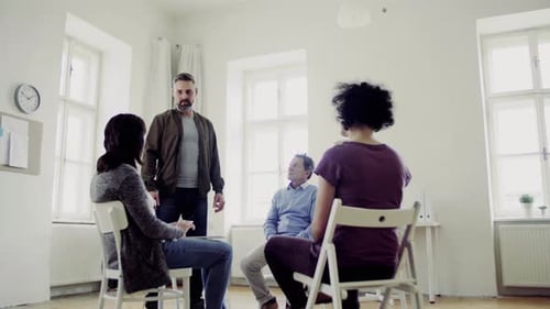 Adults Talking Together in Support Group in Bright Room
