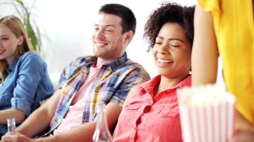 Friends Relaxing with Drinks and Popcorn at Home