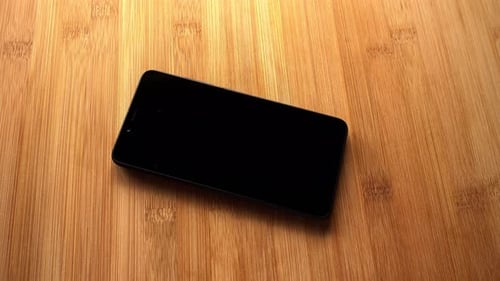 Black Smartphone on Wooden Table