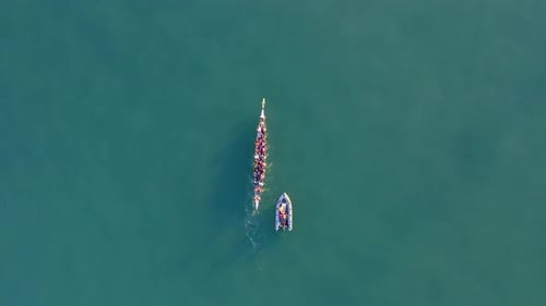 Dragon Boat team rowing to the pace of an onboard Drummer.