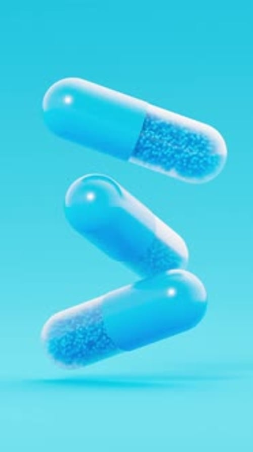 3D Medical Capsules Rotating and Falling in Blue Space